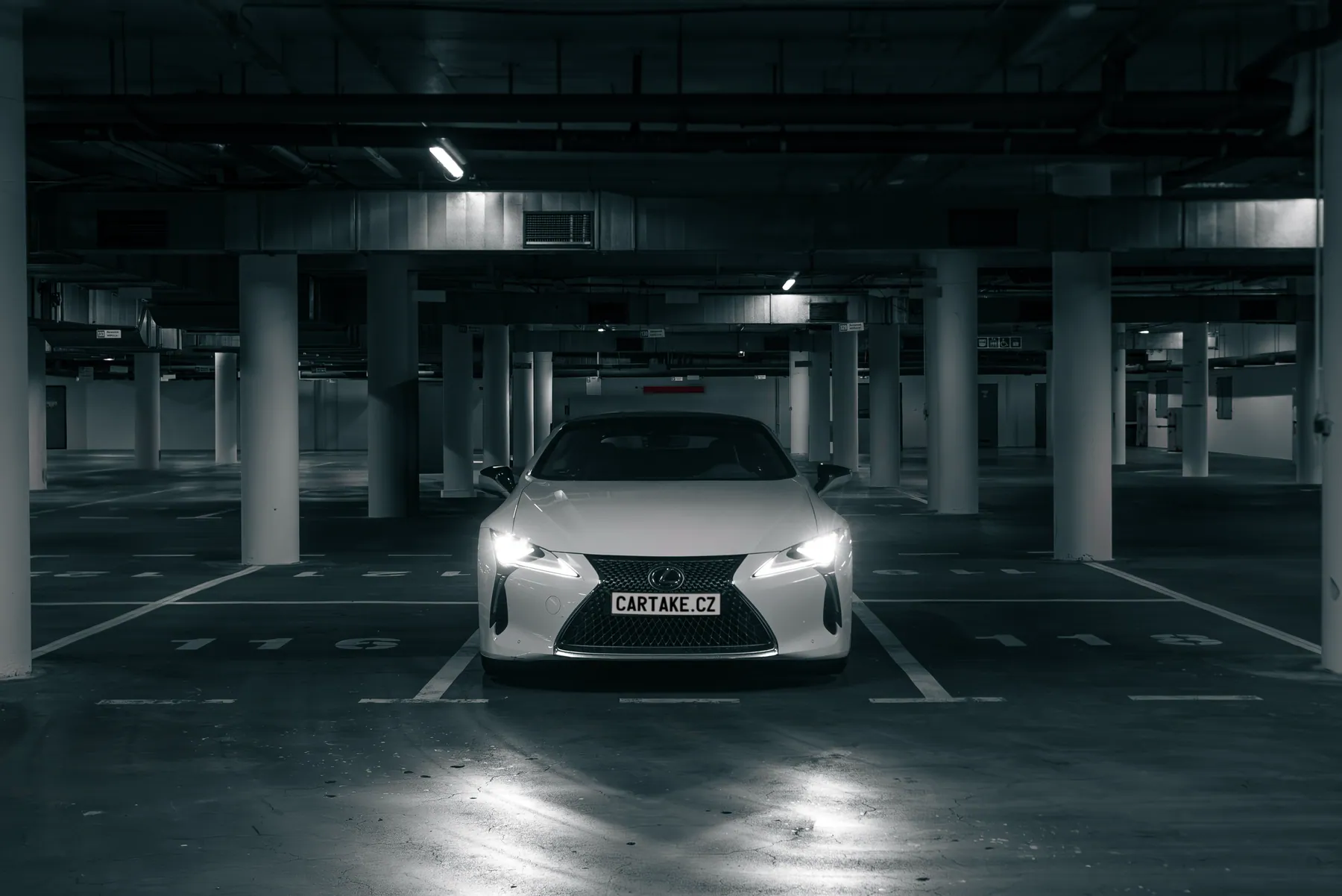 Lexus LC 500 Cabrio zepředu s rozsvícenými světlomety