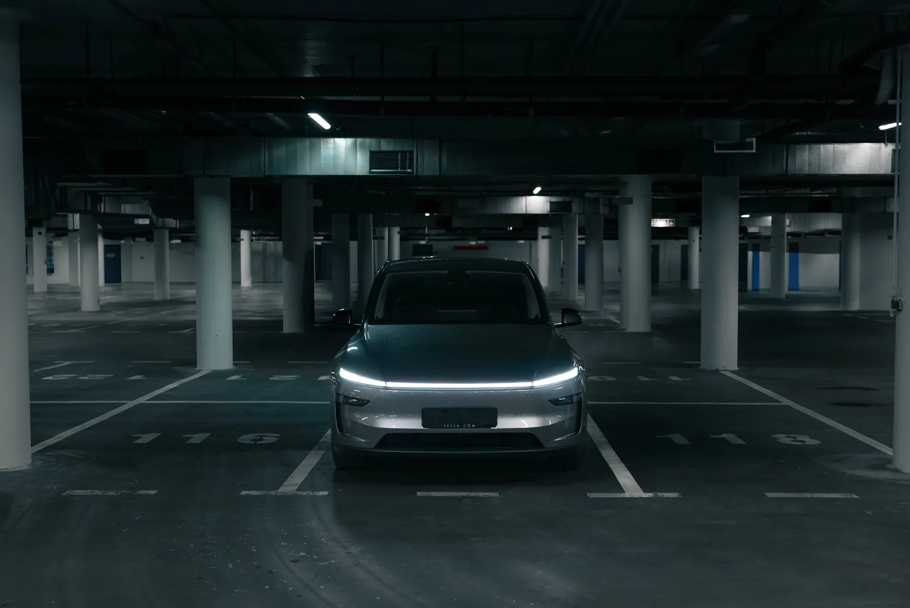 Tesla Model Y zepředu s rozsvícenou světelnou lištou